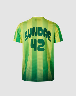 Sundae School Sour Yuzu lime green and yellow soccer jersey featuring "SUNDAE 42" back text branding with halftone dot pattern, yellow and green vertical stripe details on shoulders, green collar with contrast trim, athletic fit silhouette, flat lay product shot on light background, shown from back view.