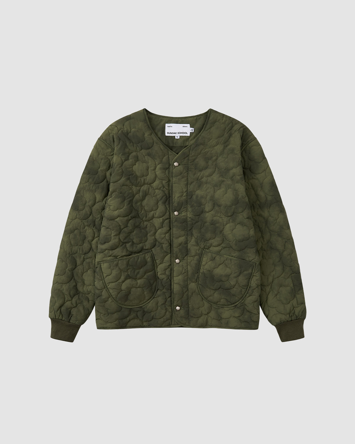 The Sundae School MATCHA MOCHI QUILTED MILITARY LINER in olive green features front snap buttons, two large patch pockets, and a round neckline—ideal for transitional weather—shown on a plain white background.