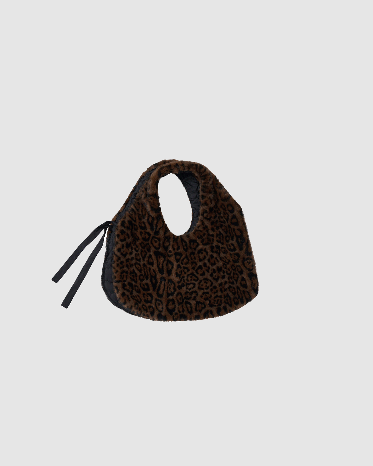 The BLACK LEOPARD BAEJA VEST / BAG by Sundae School is a small, soft faux fur bag with brown and black leopard print, black ribbon ties on one side, and a rounded handle opening, shown on a plain light gray background.