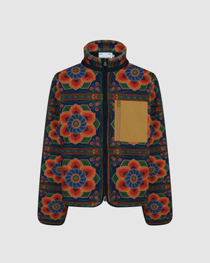 Sundae School Dancheong Fleece featuring vibrant Korean temple-inspired pattern with orange and blue lotus flowers on navy background, full-zip front with contrast tan chest pocket, high collar, flat shot on light gray background.