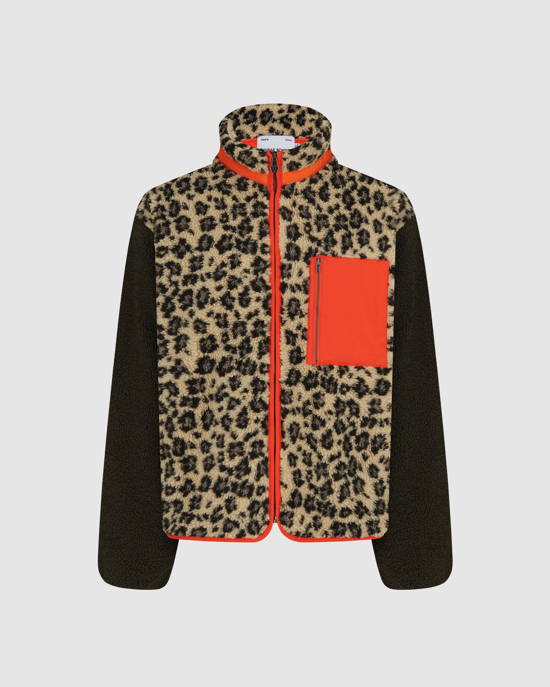 The Tiger Mom Fleece by Sundae School features a sherpa leopard print front and collar, black sleeves and sides, orange trim on the zipper and hem, plus an orange chest pocket—a cozy style inspired by the viral Barefoot Jacob look.
