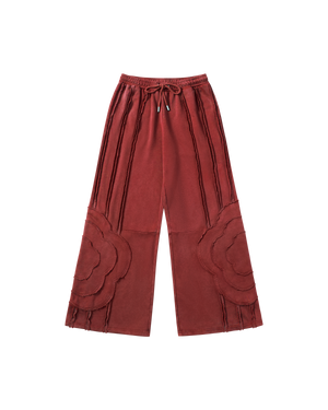 Red Mochi Haze Paneled Sweatpants featuring washed red cotton with exposed curved seam details throughout legs, elastic waistband with drawstring ties, relaxed wide-leg fit silhouette, flat lay product shot.