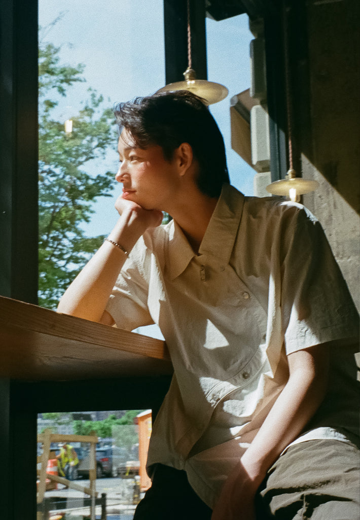 Elio gazes out the window wearing the Ivory Yin Yang Short Sleeve Shirt from Sundae School's newest collection