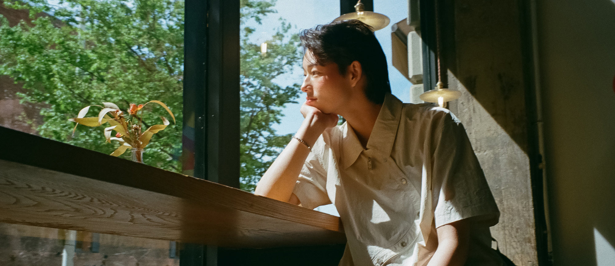 Elio gazes out the window wearing the Ivory Yin Yang Short Sleeve Shirt from Sundae School's newest collection