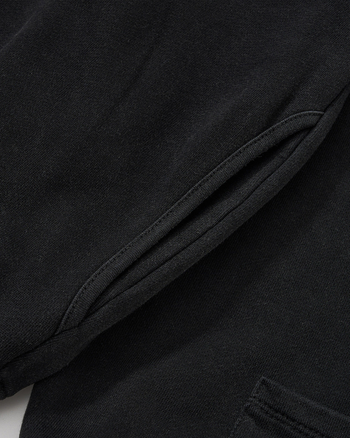 Black Fade Black Hanbok Hoodie fabric detail showing garment washed black cotton material with natural draping and construction seams, close-up flat lay shot.