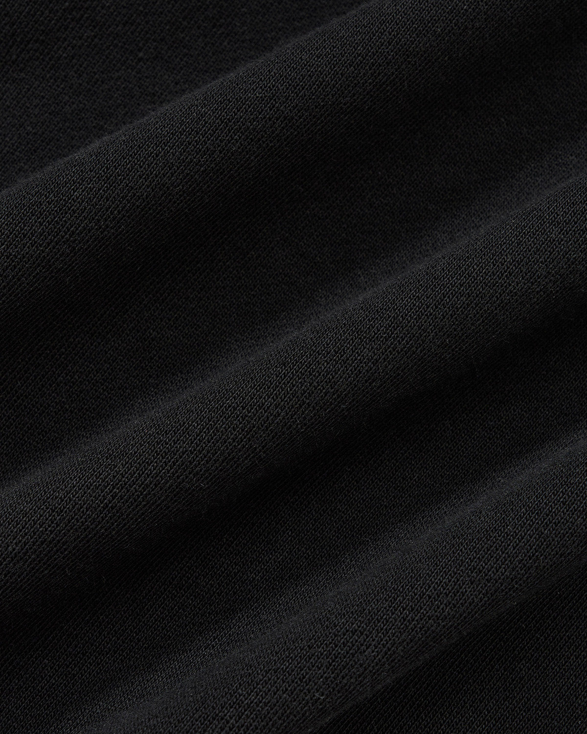 Black Fade Black Hanbok Hoodie fabric texture detail showing garment washed black cotton material with soft hand feel and natural fabric characteristics, close-up macro shot.