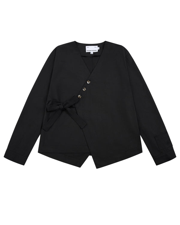 Sundae School’s BLACK HANBOK TIE BLAZER is a black long-sleeve blazer featuring a V-neckline, side tie closure inspired by the jeogori silhouette, four asymmetrical buttons, an angled hem, and a visible white tag at the neckline.