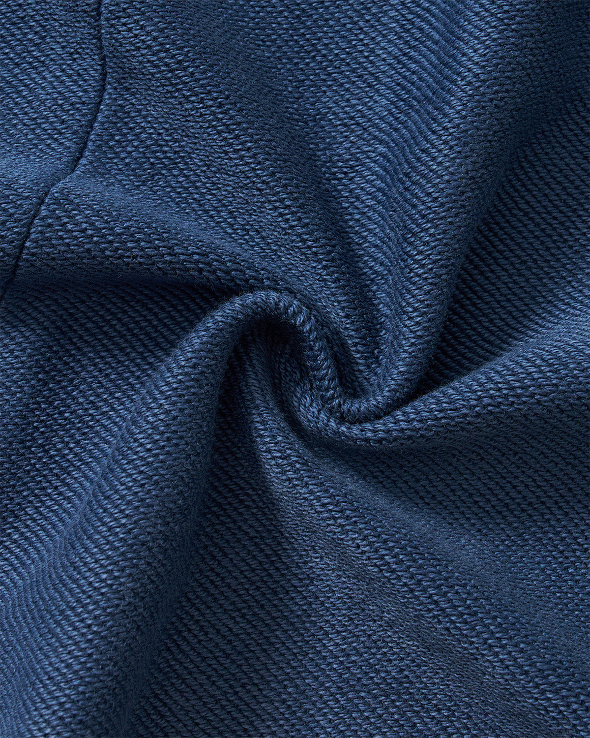 Indigo Mochi Haze Paneled Hoodie fabric texture detail showing garment washed indigo cotton material with natural weave and soft hand feel, close-up macro shot.