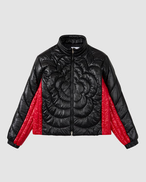 The BLACK RED MOCHI SPIRAL PUFFER by Sundae School features a black two-tone nylon shell with floral quilted patterns on the front and bold red quilted panels along the sides and sleeves, shown against a light gray background.
