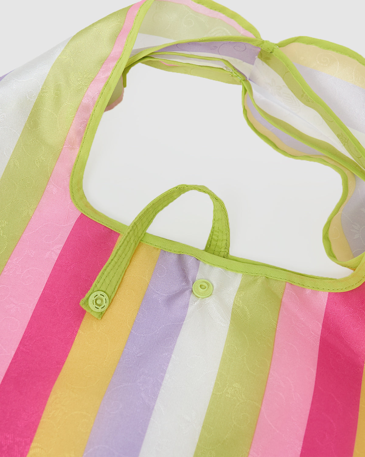 A close-up of the BIG BOJAGI TOTE BAG by Sundae School, featuring vertical pink, yellow, white, purple, and green stripes, green trim, and a snap closure near the top.