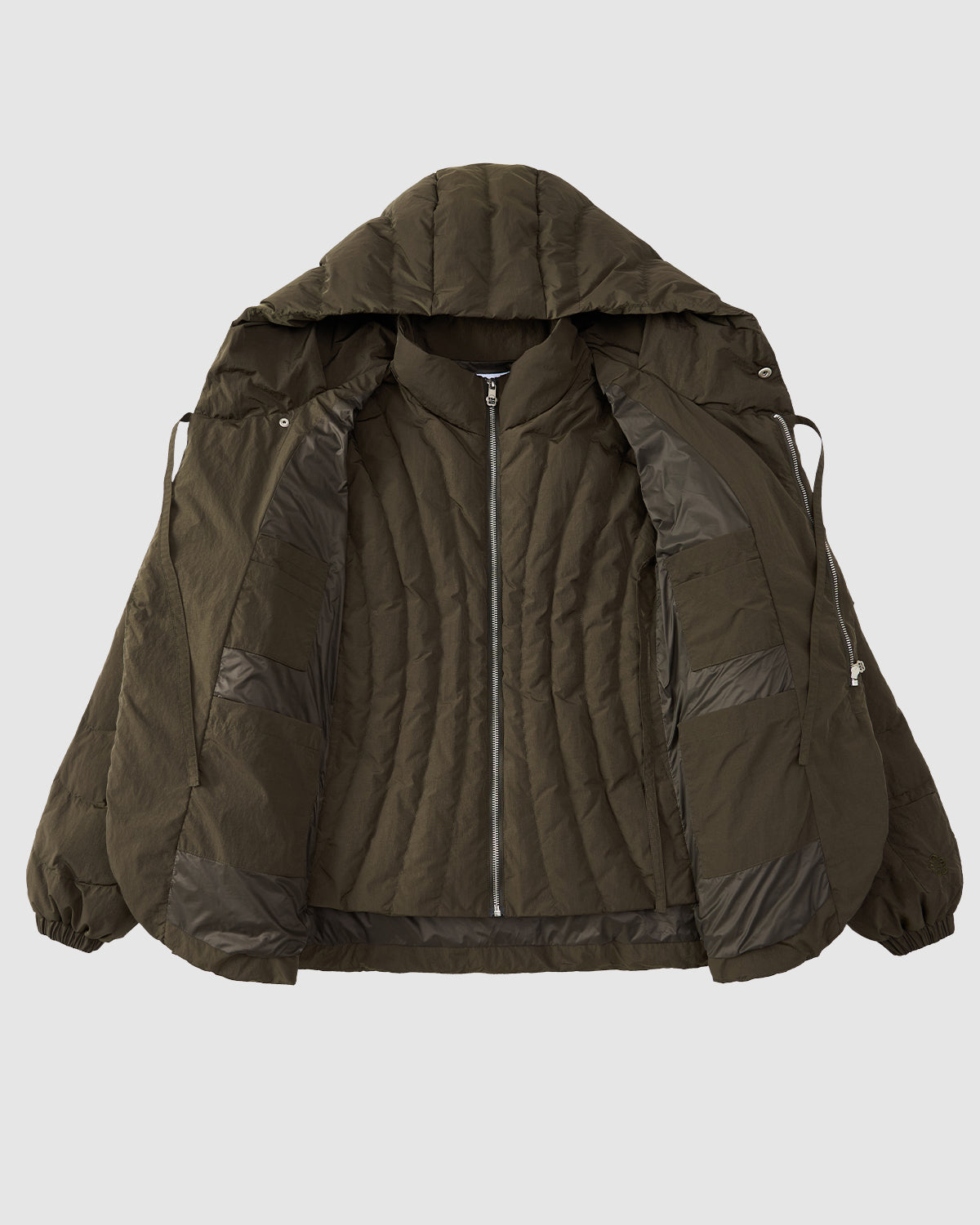 The Sundae School [PRE-ORDER] KHAKI HEAVYWEIGHT MOCHI PUFFER is shown open on a light grey background, highlighting its mochi quilting inner lining and zippered front.