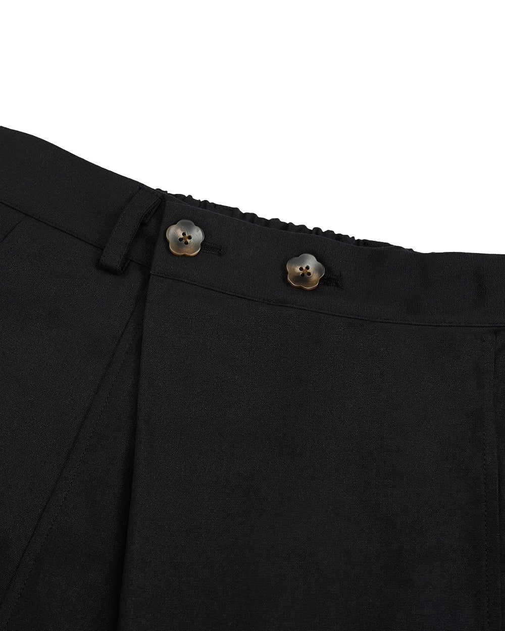 Zoomed-in view of the waistband on the BLACK HANBOK BALLOON PANTS by Sundae School, featuring two brown buttons, prominent belt loops, and pleated detailing in the 100% cotton fabric.
