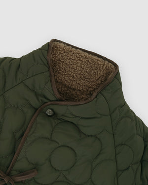 Close-up detail of the Reversible Flower Quilted Jeogori Fleece collar showing brown sherpa fleece lining and circular quilted pattern with a brown button closure.