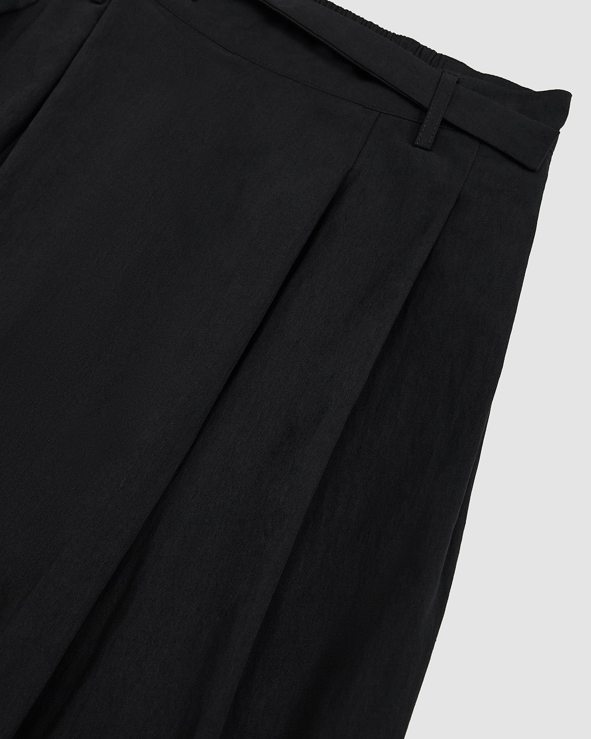 Detail view of side pleating and wide-leg silhouette of Sundae School Black Pleated Nylon Pants showing fabric drape and construction