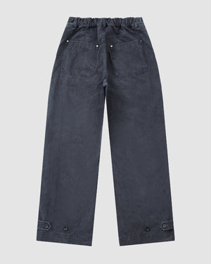 The Sundae School CHARCOAL ACCORDION CHINO PANTS are dark gray, wide-leg unisex chinos with an elastic waistband, accordion pleats, riveted back pockets, and button hem details, shown flat on a light gray background.