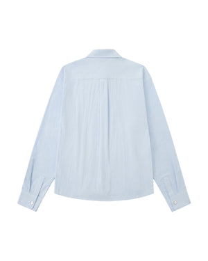 A back flat-lay view of a light blue long-sleeve shirt laid flat against a white background, showing a clean shoulder yoke, a central back box pleat, and buttoned cuffs.