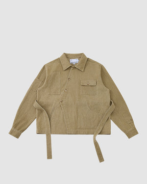 The TAN ASYMMETRIC WORK JACKET by Sundae School is a beige unisex jacket with a collar, front buttons, seven pockets, and two long side belts, shown on a plain white background.