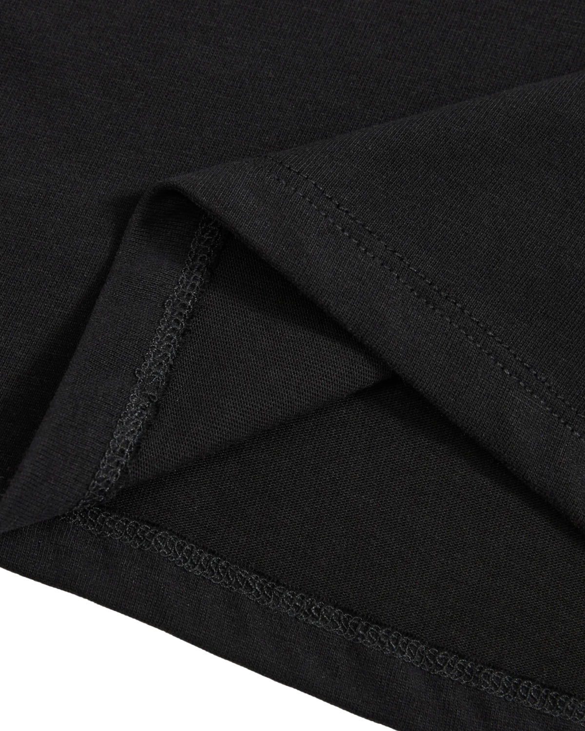 Close-up of the hem and stitching on the BLACK TIE GORUM BABY TEE by Sundae School, highlighting the detailed seams and folded fabric edges on this black cotton jersey cropped baby tee.