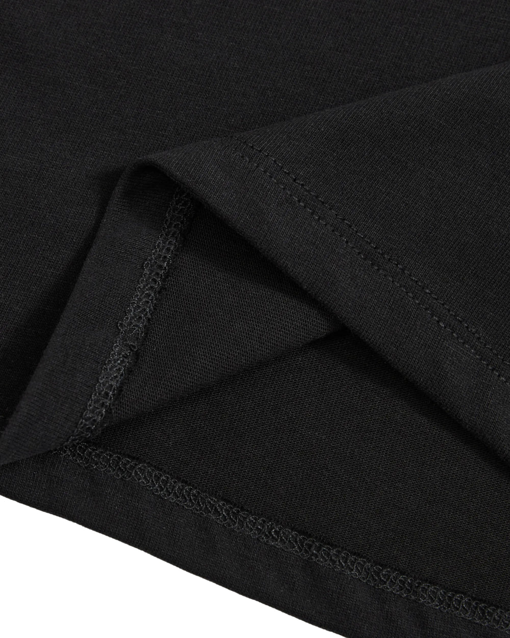 Close-up of the hem and stitching on the BLACK TIE GORUM BABY TEE by Sundae School, highlighting the detailed seams and folded fabric edges on this black cotton jersey cropped baby tee.