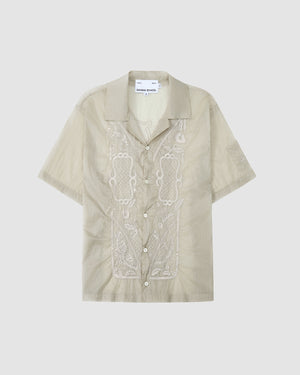 The BARONG SHIRT by Sundae School is a light beige, short-sleeve button-up with a collar and white embroidery on the front. Inspired by the Barong Tagalog, it offers a relaxed fit and casual style.