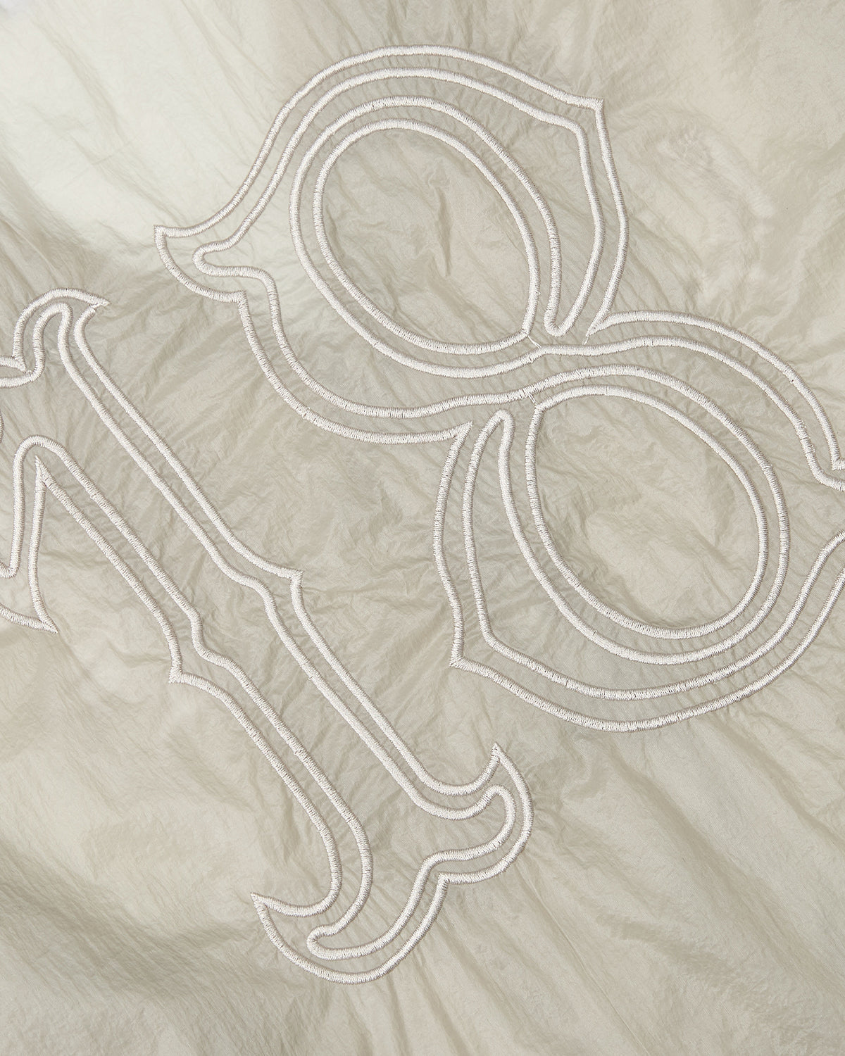 Close-up of the BARONG SHIRT by Sundae School, featuring light fabric with a white-stitched number 18, textured and slightly wrinkled, echoing the look of a traditional Barong Tagalog in a modern nylon-translucent style.