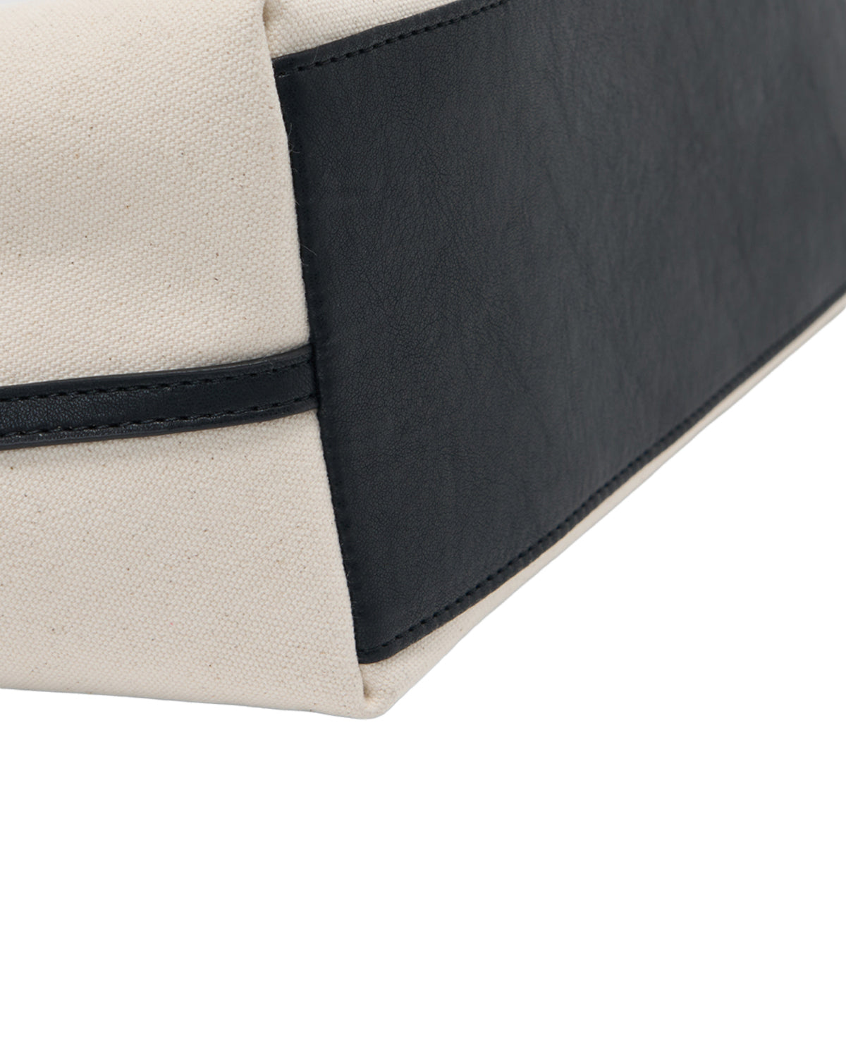 Close-up of the IVORY BOJAGI TIE TOTE BAG by Sundae School, showing a rectangular section where beige fabric and black vegan leather trim are neatly stitched together.