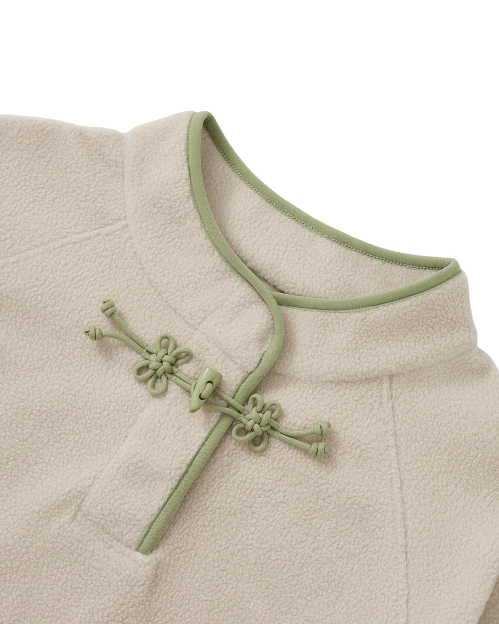 Close-up of the TAUPE BUTTERFLY FLEECE PULLOVER by Sundae School: a cream-toned mock-neck polar fleece pullover accented with light green trim and a traditional Chinese frog button closure at the collar, featuring delicate hand-tied flower knots for added artisanal flair.