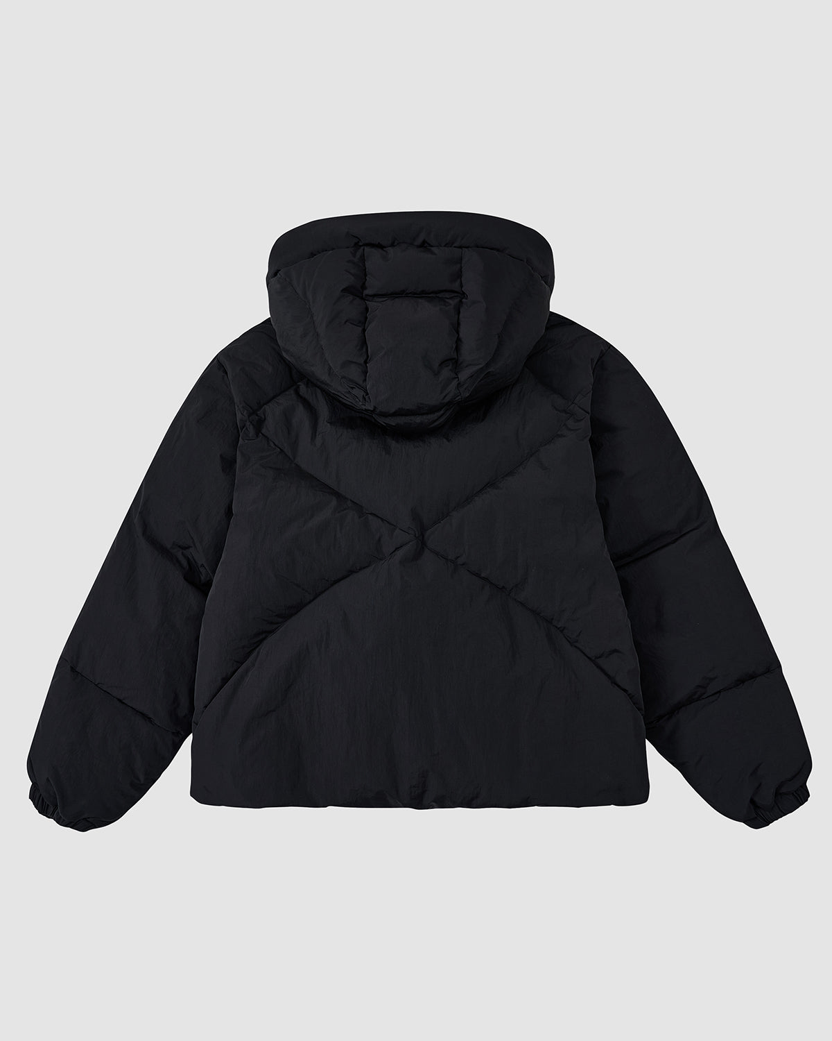The BLACK SKY BLUE ORIGAMI PUFFER by Sundae School is a black puffer jacket with a hood, featuring diagonal quilted stitching and elastic sleeve cuffs, shown from the back against a light gray background.
