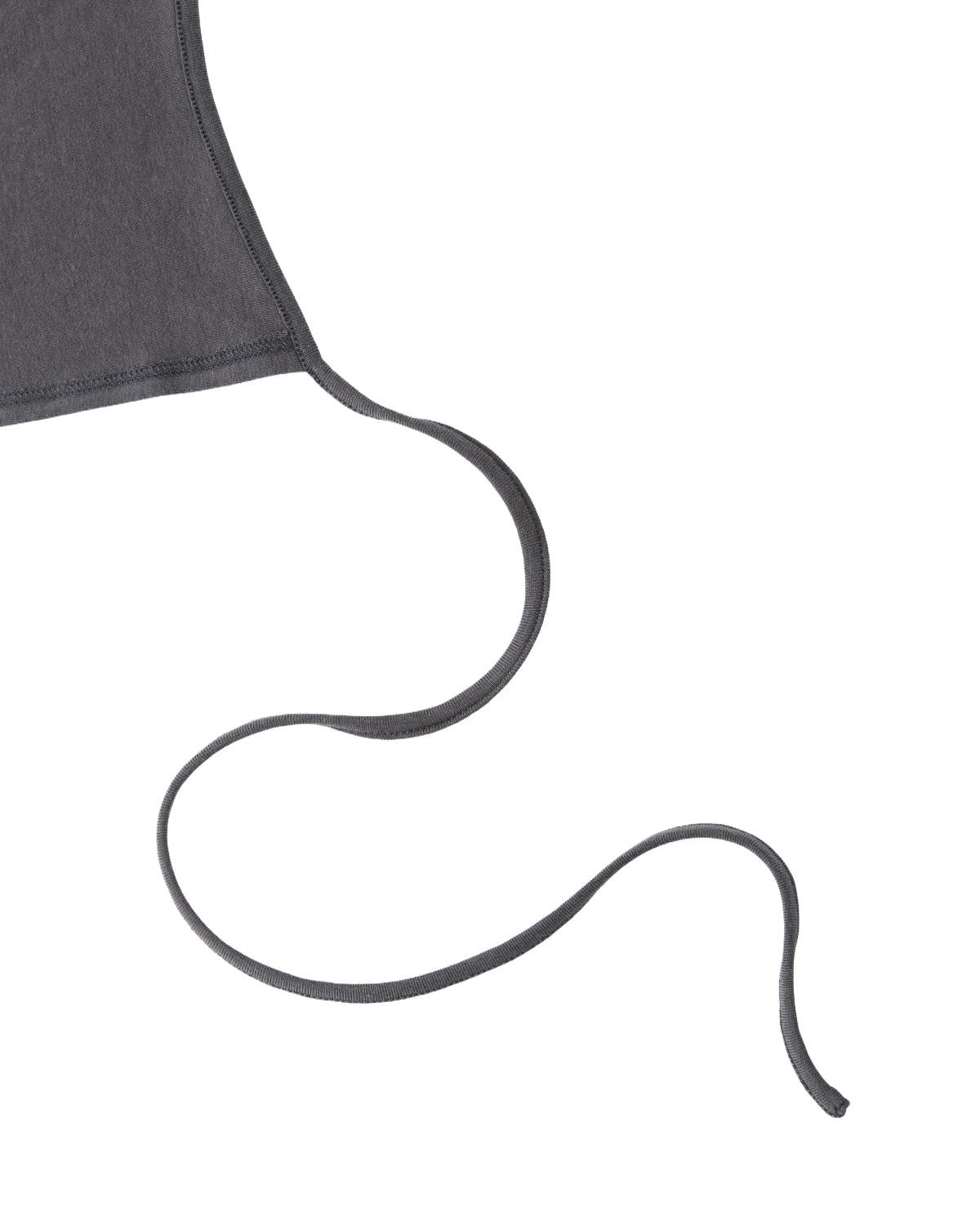 Close-up of the corner of the DARK GREY CINDY POLO DRESS by Sundae School, with a long, thin dark gray tie extending and curving smoothly on a white background.