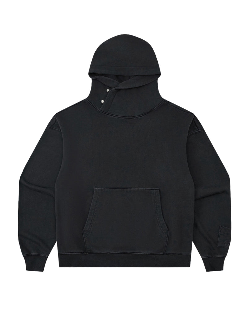 The FADE BLACK COCOON HOODIE by Sundae School is a black hooded sweatshirt featuring long peret sleeves, a front pocket, and a distinctive cross-button closure at the neck. Designed with an oversized hood, the hoodie is shown laid flat against a white background.