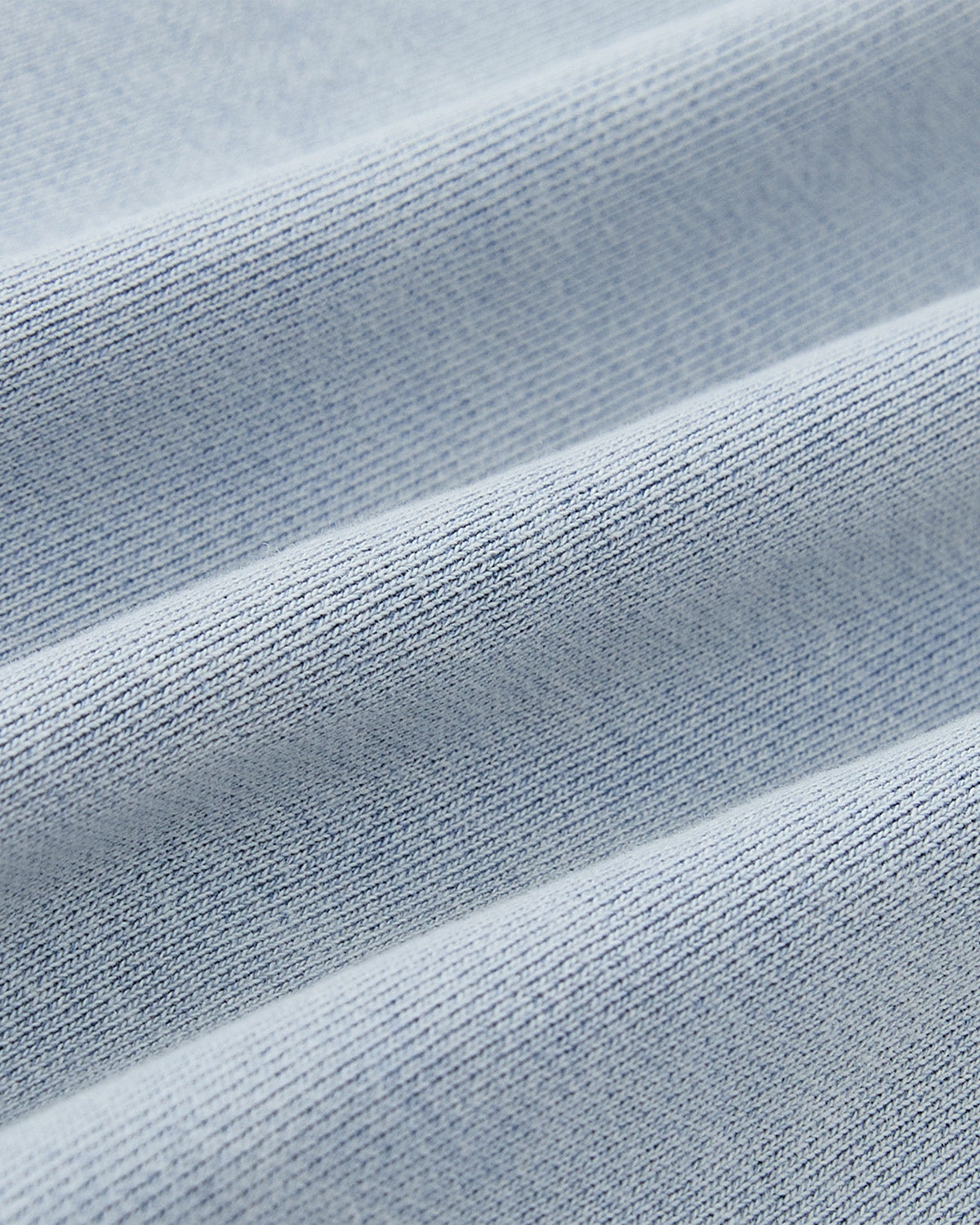 Close-up of the SKY BLUE COCOON HOODIE by Sundae School shows light blue, ribbed fabric with a fine woven texture and soft feel—ideal for cocoon-core looks or oversized hood styles.