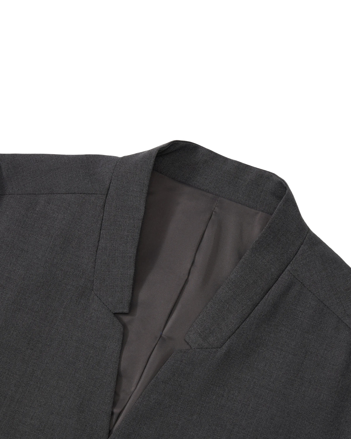 A close-up of the COLLARLESS TIE BLAZER by Sundae School displays the refined collar and lapel against a white background, showcasing the inner lining and precise tailoring that emphasize its unstructured drape for a contemporary, effortless silhouette.