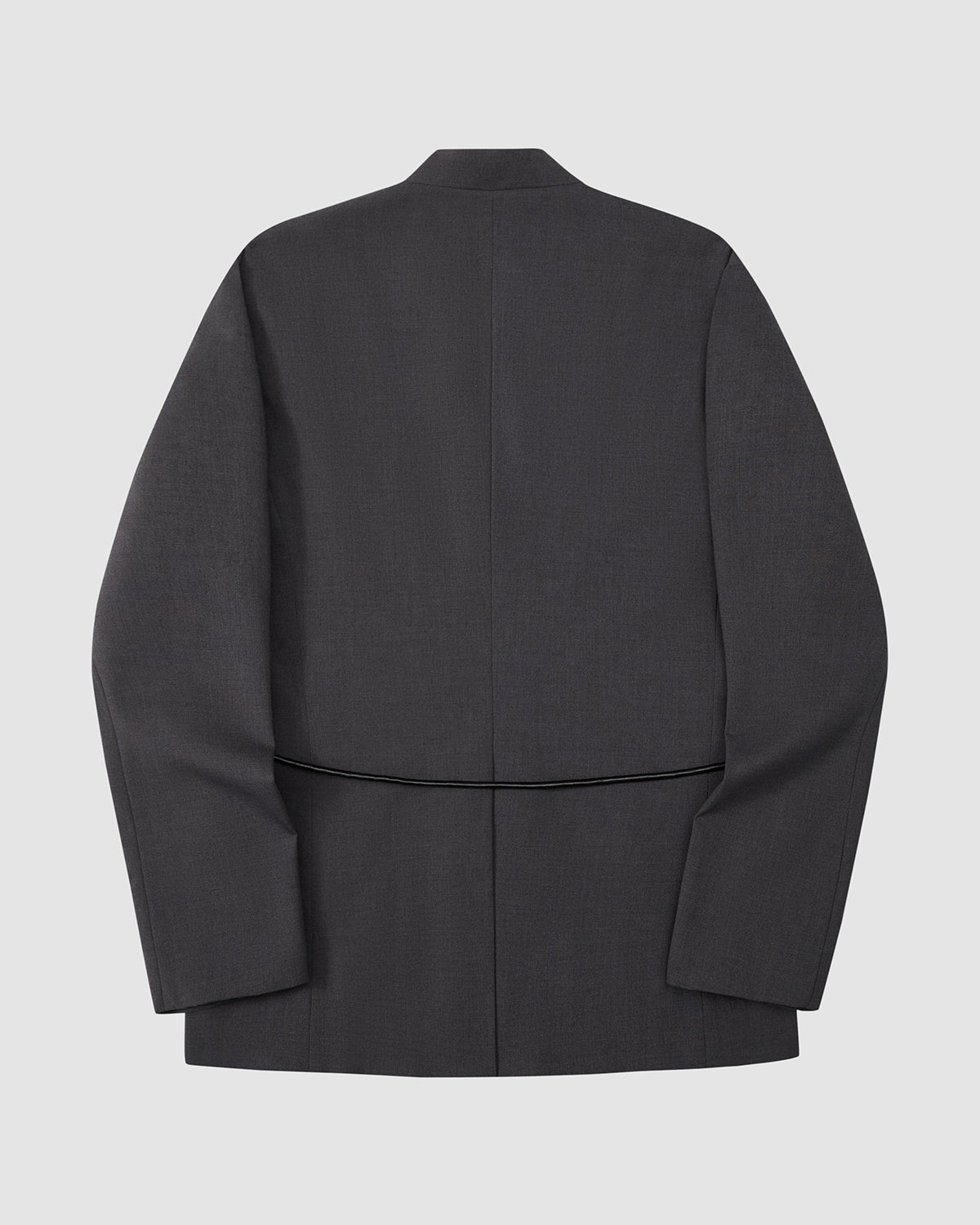 Sundae School’s COLLARLESS TIE BLAZER in dark gray is shown from the back against a light gray background. This collarless summer wool piece features a clean, tailored design, central seam, structured shoulders, and breathable finish.