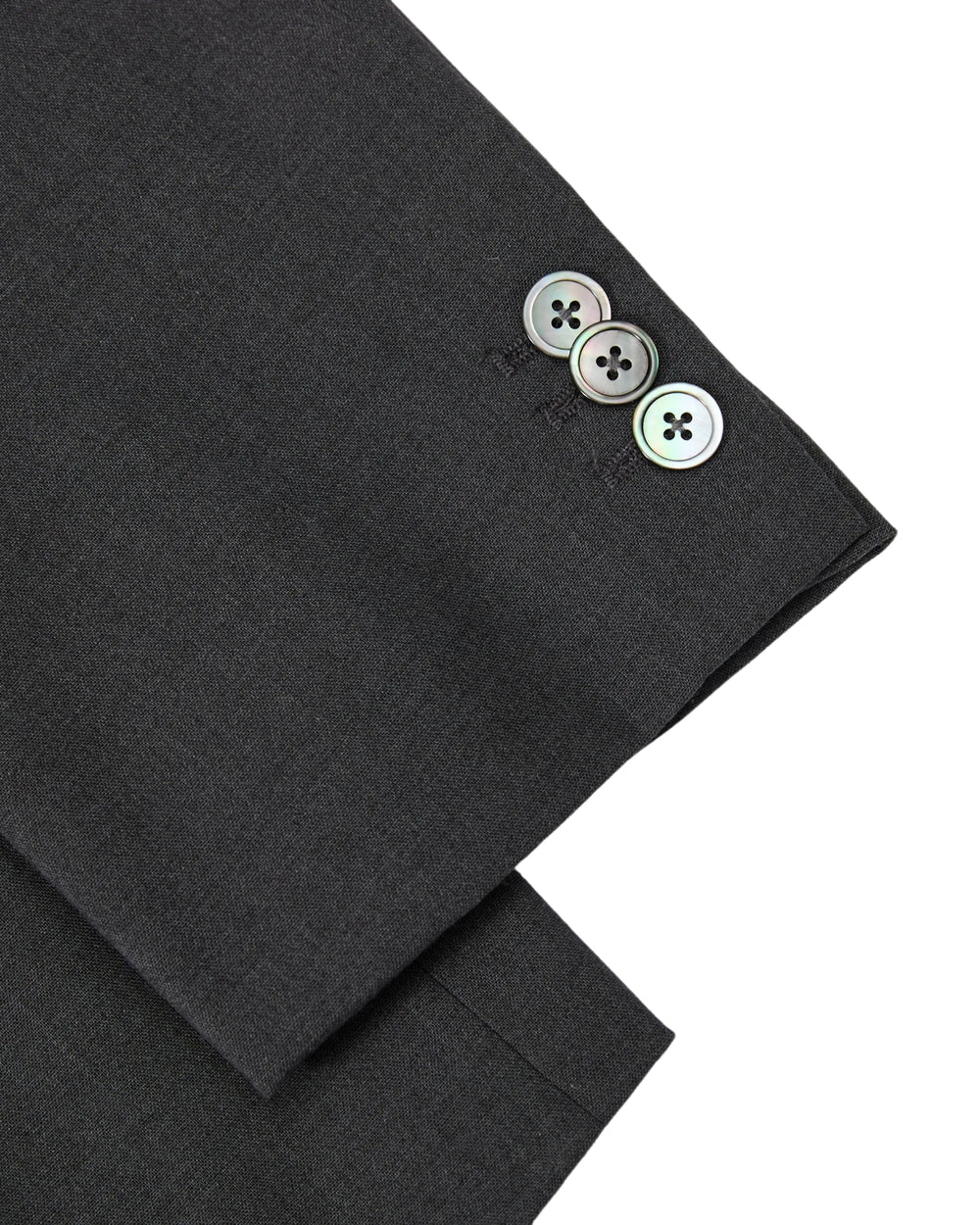 A close-up of the Sundae School COLLARLESS TIE BLAZER’s sleeve showcases three shiny buttons neatly stacked near the cuff, highlighting the dark, collarless summer wool design.