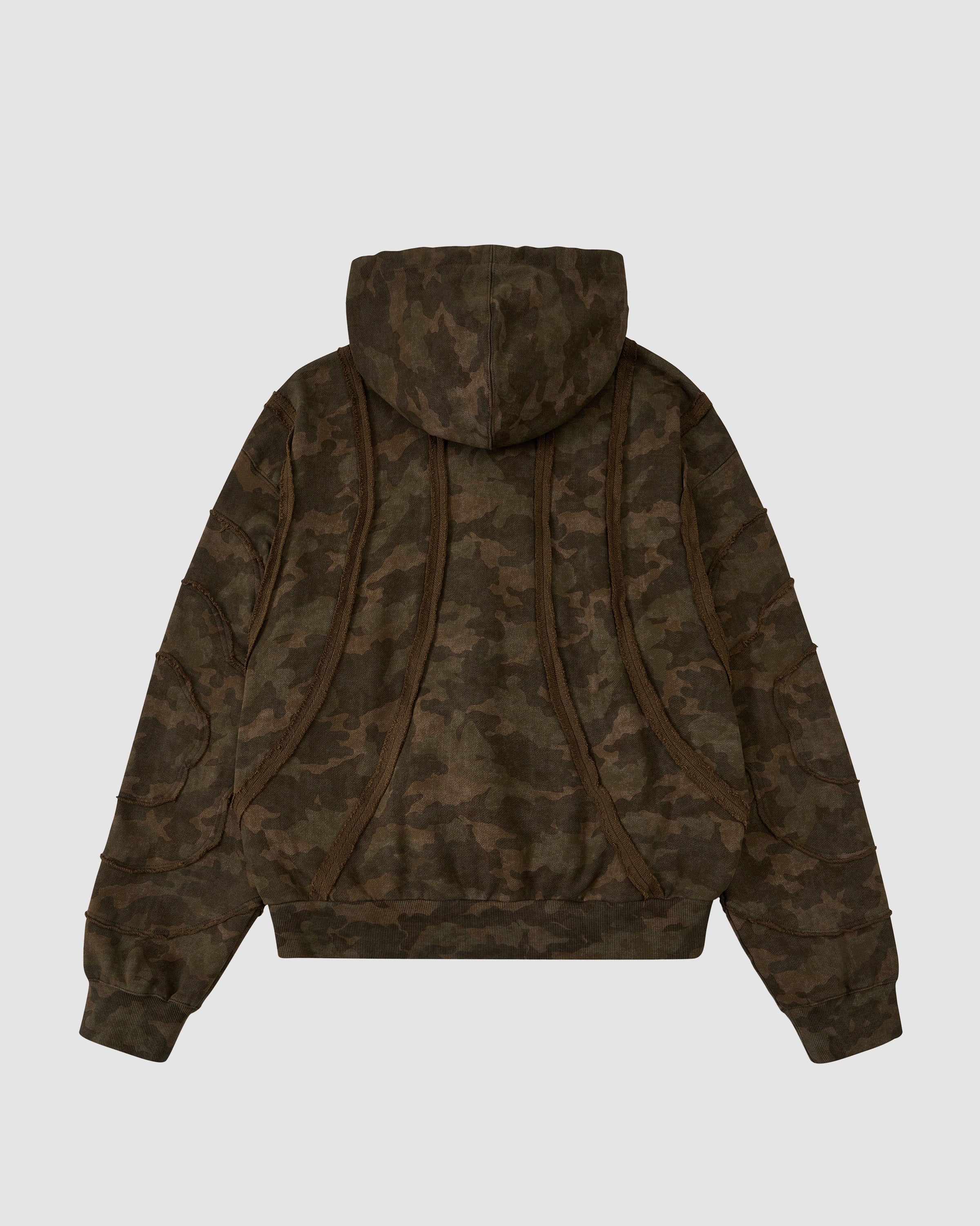 The Sundae School CAMO MOCHI HAZE PANELED ZIP UP HOODIE is a 100% cotton camo-patterned hoodie with raw seam panels, curved back seams, ribbed cuffs and waistband, shown against a plain white background.