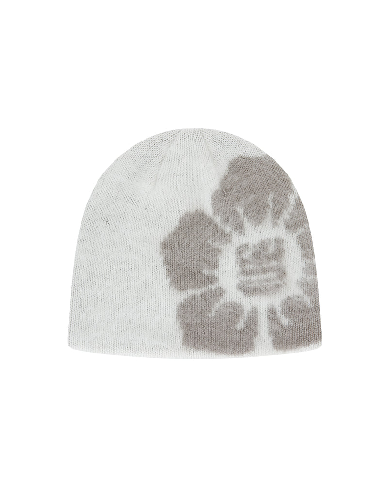 The Ivory Ddul Beanie by Sundae School is a white acrylic hat featuring a bold gray abstract flower on one side, combining stylish design with brain protection, shown on a plain light background.