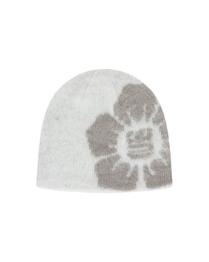 The Ivory Ddul Beanie by Sundae School is a white acrylic hat featuring a bold gray abstract flower on one side, combining stylish design with brain protection, shown on a plain light background.