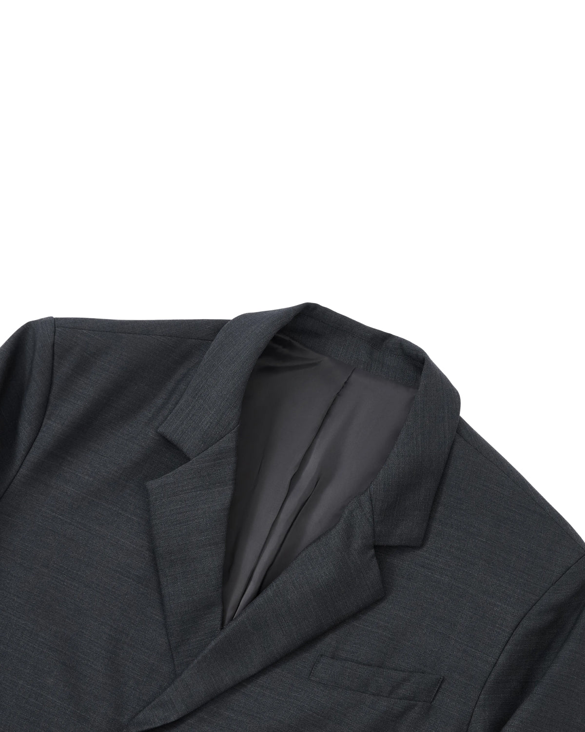 The CHARCOAL DOUBLE DUTY BLAZER by Sundae School is showcased laid flat on a white background, captured from the upper chest to the collar. The open jacket reveals its smooth, dark inner lining—an indication of meticulous craftsmanship. With no buttons or accessories visible, its clean lines and minimalist aesthetic evoke the modern hanbok silhouette. Crafted from a premium wool blend in dark gray charcoal.