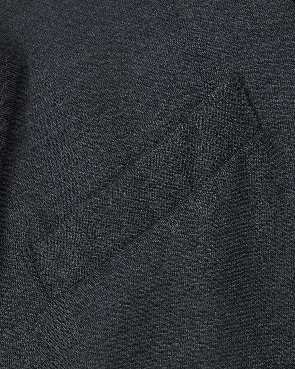 Close-up of the CHARCOAL DOUBLE DUTY BLAZER by Sundae School, featuring a small, angled welt pocket expertly stitched into the dark gray premium wool-blend fabric. The material’s refined texture highlights careful craftsmanship and an elevated hanbok-inspired silhouette.