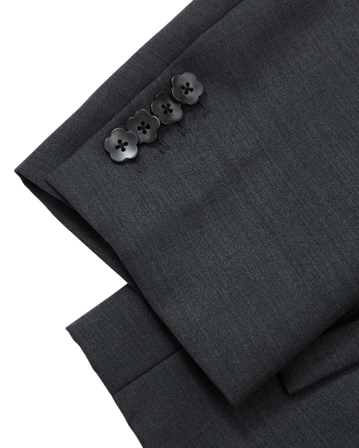 Close-up of the Sundae School CHARCOAL DOUBLE DUTY BLAZER sleeve in dark gray, featuring four neatly arranged black buttons at the cuff. The premium wool blend fabric reveals a subtle texture, highlighting the blazer’s exceptional quality and meticulous tailoring. Inspired by hanbok silhouettes, this refined piece perfectly merges traditional influences with modern elegance.