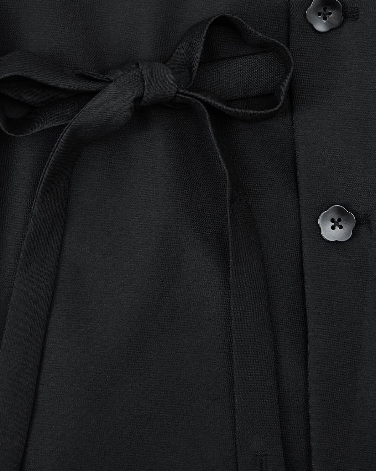 Close-up of Sundae School’s BLACK DOUBLE DUTY BLAZER in black, featuring a hidden goreum tie at the waist and three black flower-shaped buttons along the edge.