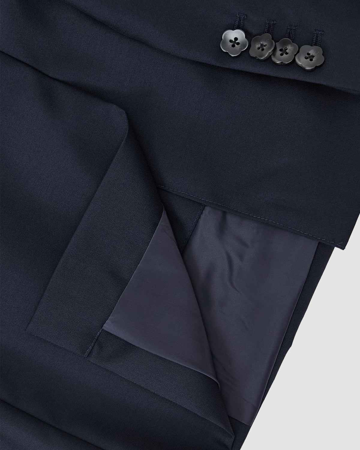 Close-up of the Sundae School NAVY DOUBLE DUTY BLAZER cuff, featuring four black buttons and a smooth, slightly shiny inner lining.