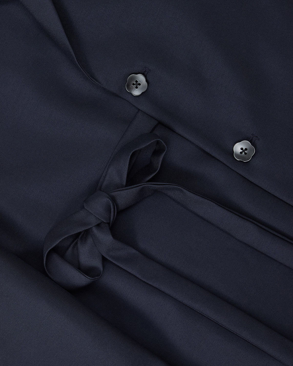 Close-up of the Sundae School NAVY DOUBLE DUTY BLAZER, a dark navy wool-blend piece with two black buttons and a fabric belt, inspired by hanbok silhouettes and designed to be worn as a dress or coat.