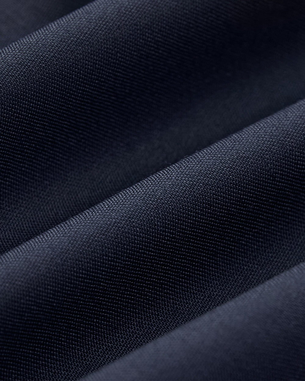 Close-up of Sundae School’s NAVY DOUBLE DUTY BLAZER fabric in dark blue, featuring a fine weave, soft folds, and a smooth, slightly shiny texture reminiscent of a wool blend blazer with graceful drape.