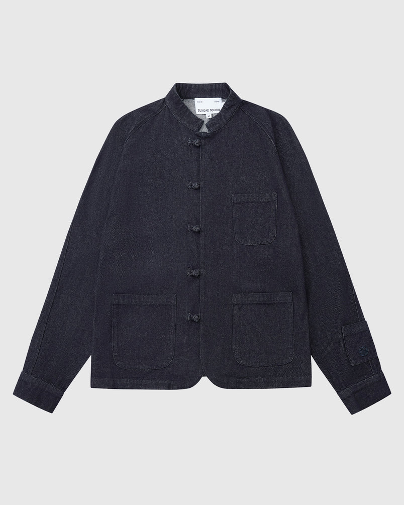 The Sundae School DENIM CHORE JACKET features dark denim, a mandarin collar, three front patch pockets, a button-up front, and long sleeves, shown laid flat on a white background.