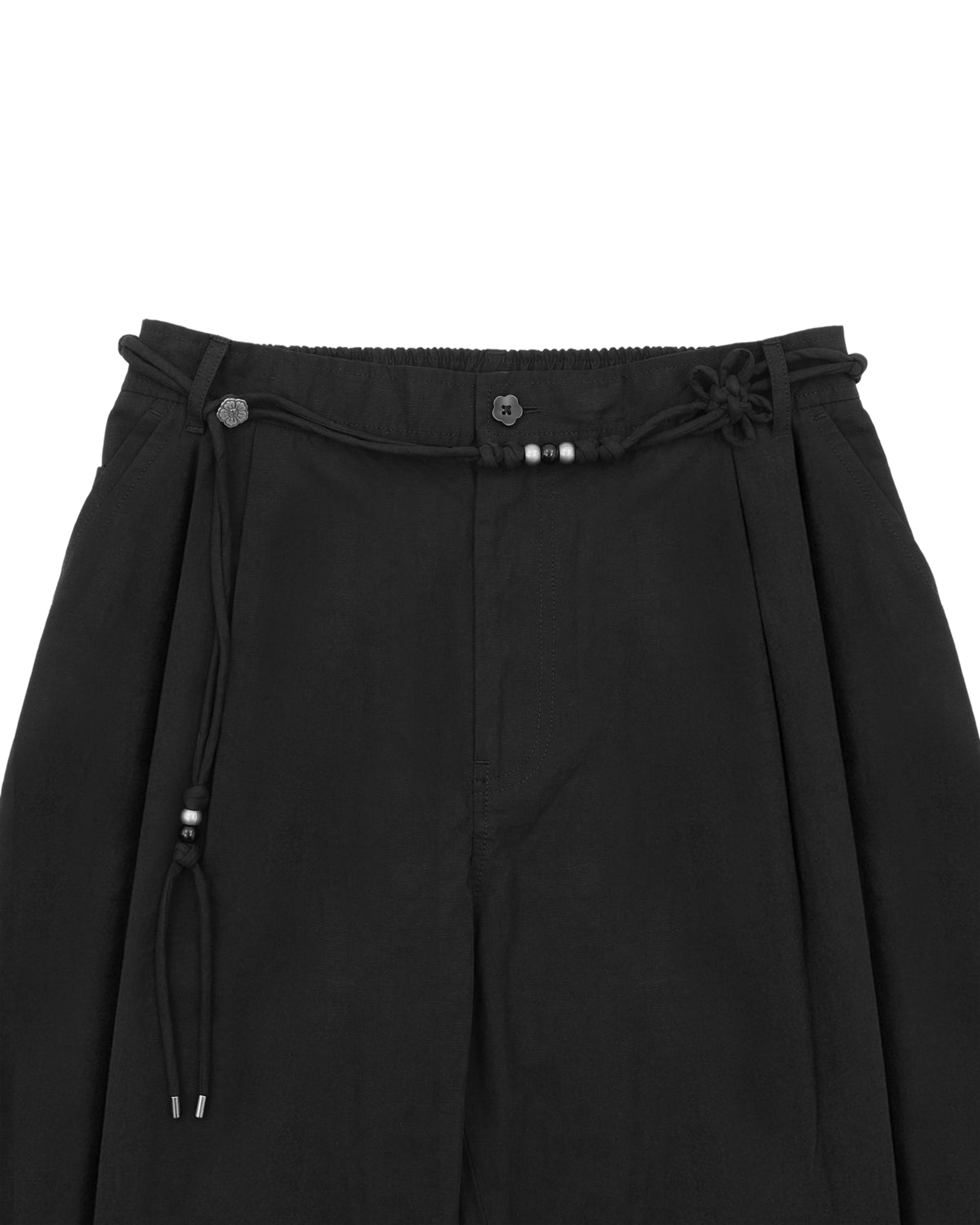 The BLACK FLOWER NORIGAE LINEN TROUSERS by Sundae School feature a decorative norigae belt with beaded accents, button details at the waistband, and are crafted from a soft, lightweight fabric that highlights their Korean-inspired charm. Shown from the waist to mid-thigh.
