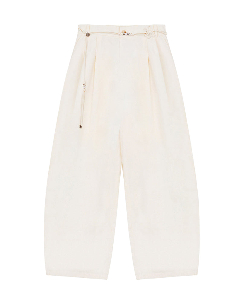 The IVORY FLOWER NORIGAE LINEN TROUSERS by Sundae School are high-waisted, wide-leg cream-colored pants crafted from a cotton-linen blend. Featuring balloon-shaped legs, pleats, an ankle-length cut, and a slim matching norigae belt, these trousers offer a loose, comfortable fit.