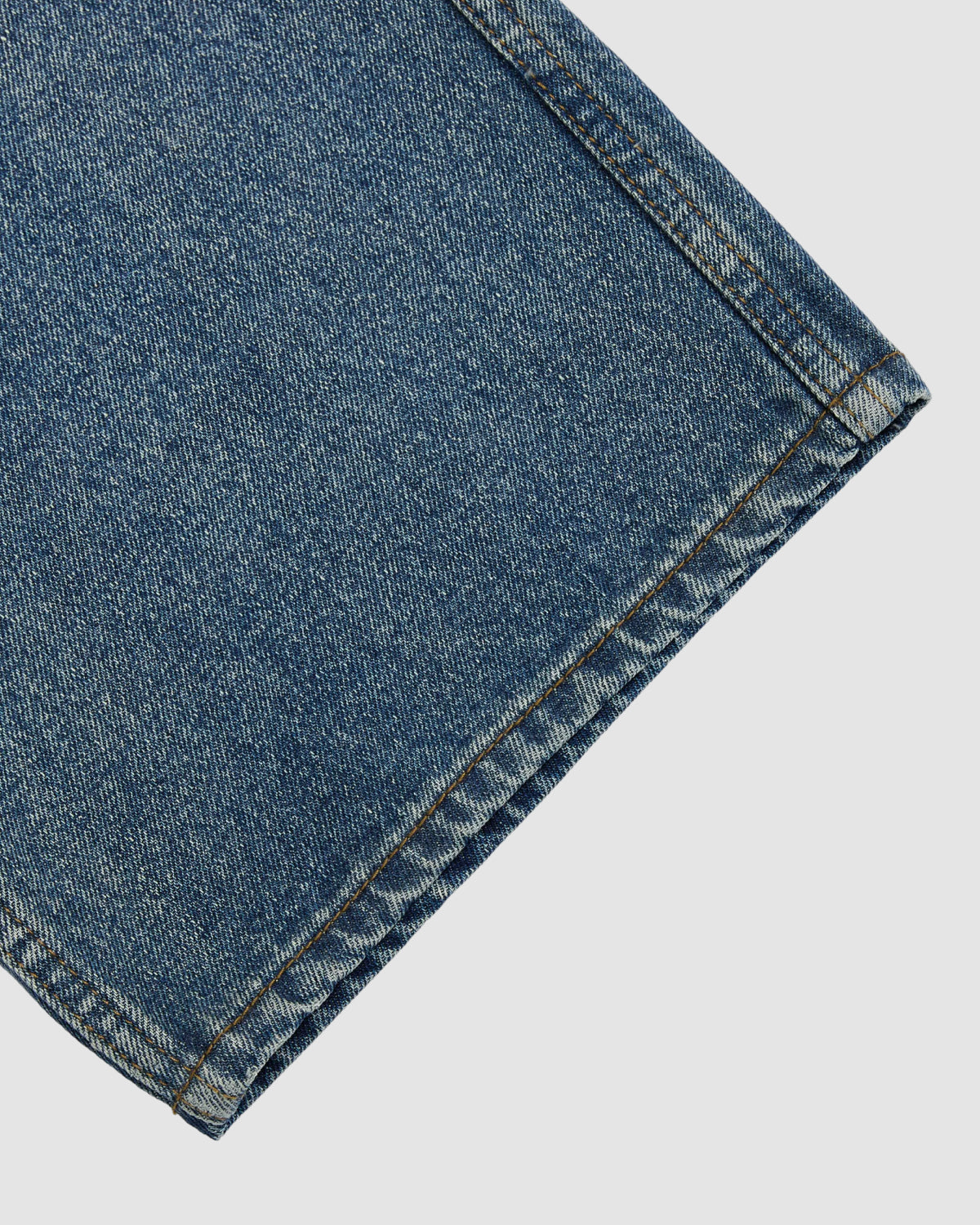 Close-up of the hem and detailed stitching on Sundae School’s MEDIUM BLUE FRESHMAN FIT DENIM jeans, highlighting the fabric texture against a plain white background.