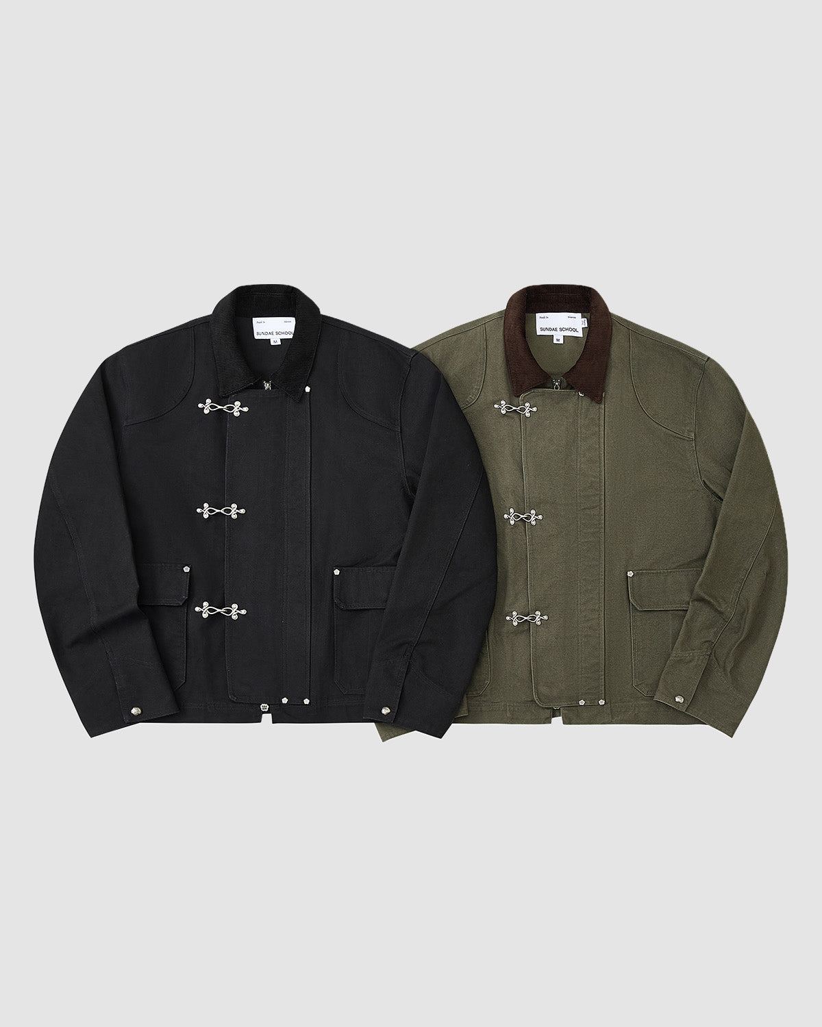 Two jackets from Sundae School on a light gray background: the [PRE-ORDER] BLACK FIREMAN CLASP JACKET with matching collar, and an olive green vintage cotton style with brown collar. Both have large flap pockets and metal clasp closures.