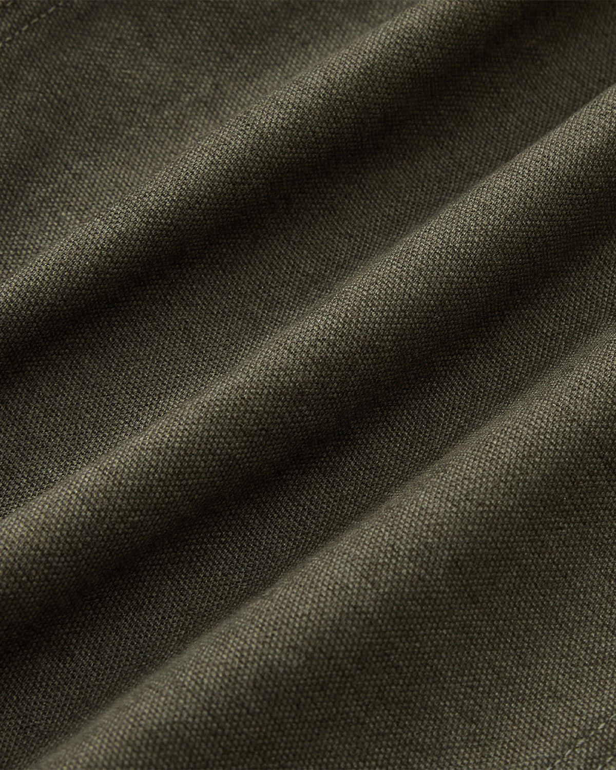 Close-up of the olive green fabric with visible weave and soft folds highlights the texture and softness—ideal for the [PRE-ORDER] OLIVE FIREMAN CLASP JACKET by Sundae School.